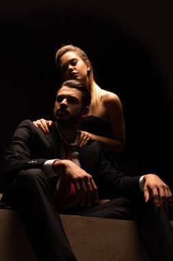 Şehvetli, zarif bir çift karanlık odada yatakta oturuyor.