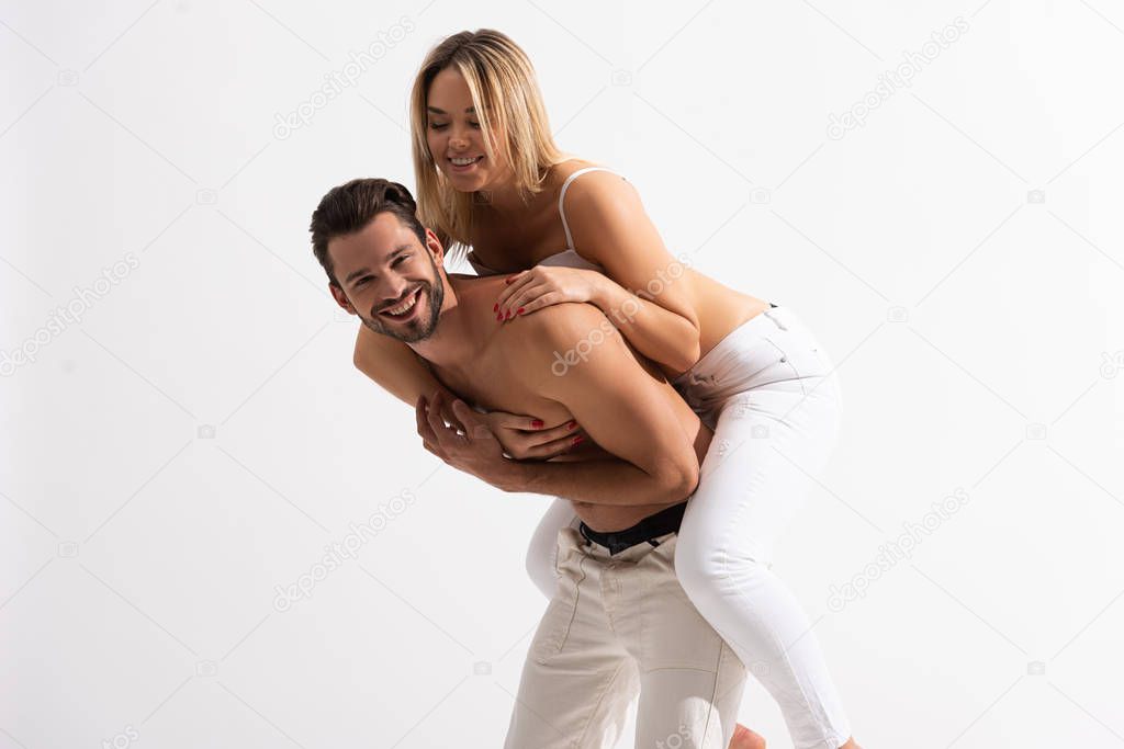 cheerful sexy couple piggybacking, isolated on white
