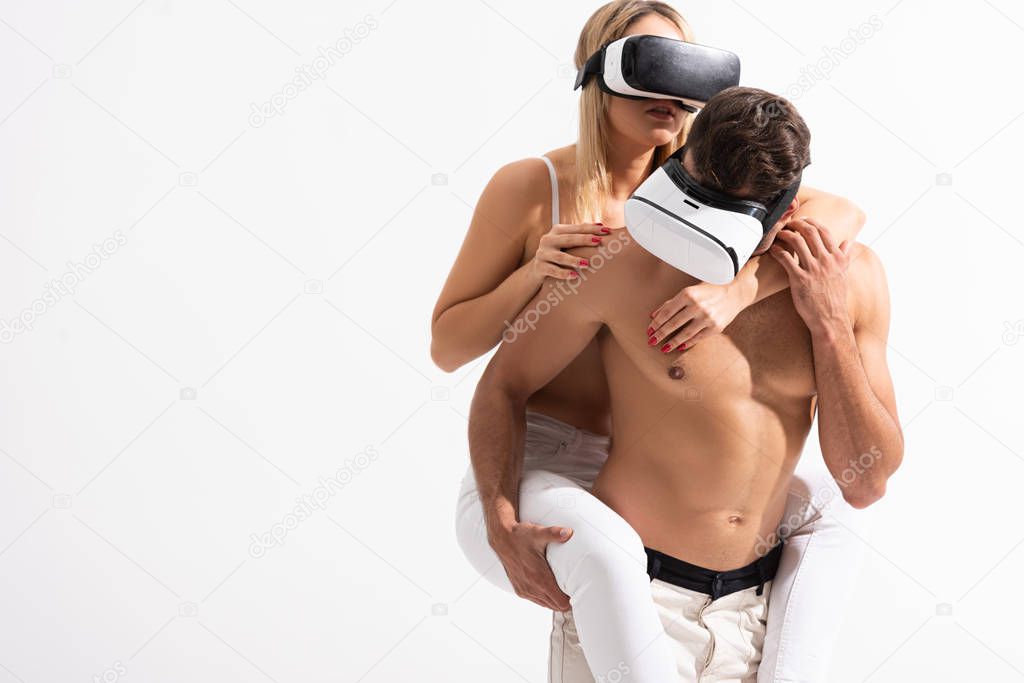 sexy couple in Virtual reality headsets piggybacking isolated on white