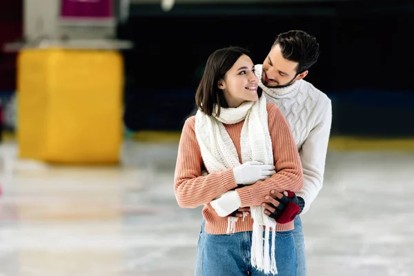Young Positive Couple Sweaters Hugging Skating Rink — Stock Photo, Image