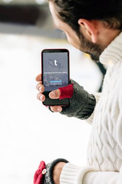 Kyiv, Ukrayna - 15 Kasım 2019: Eldivenli bir adamın ekranda, paten sahasında akıllı telefon tutarken görüntüsü