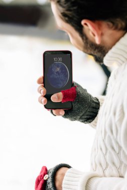 Kyiv, Ukrayna - 15 Kasım 2019: akıllı telefon tutan, buz pateni pistinde eldivenli adam görüntüsü