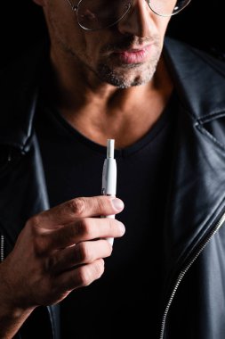 Kyiv, Ukrayna - 11 Ekim 2019: Siyah üzerinde Iqos tutan şık adam görüşü 