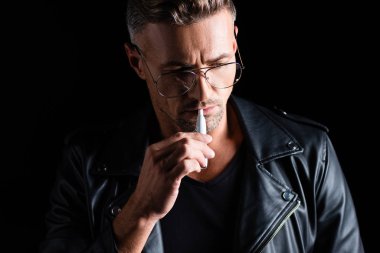Kyiv, Ukrayna - 11 Ekim 2019: Siyah üzerinde sigara içen yakışıklı adam 