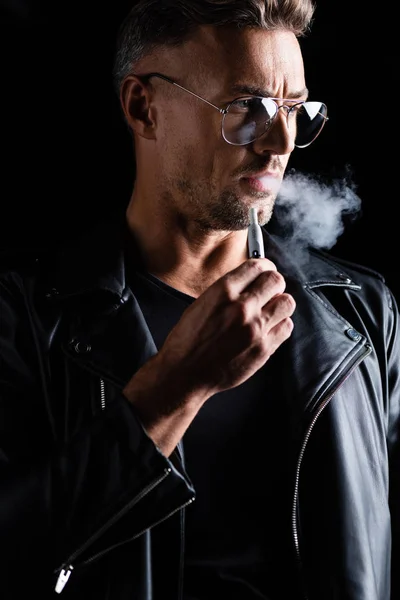 キエフ ウクライナ 2019年10月11日 黒で隔離された革のジャケット喫煙Iqosのハンサムな男 — ストック写真