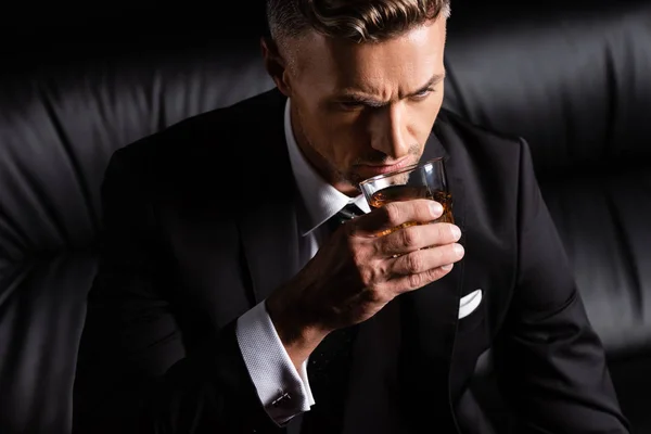 Uomo Affari Che Beve Whisky Sul Divano Isolato Nero — Foto Stock