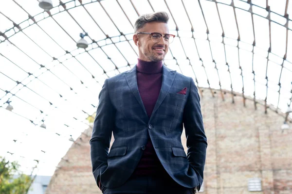 Uomo Affari Sorridente Auricolari Senza Fili Guardando Lontano Sulla Strada — Foto Stock