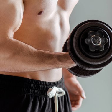 Çıplak gövde egzersizi yapan seksi kaslı vücut geliştirici görüntüsü gri halterli halterle izole edilmiş.