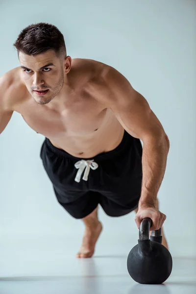 Sexy Muscular Bodybuilder Bare Torso Doing Push Ups Kettlebell Grey — Stock Photo, Image