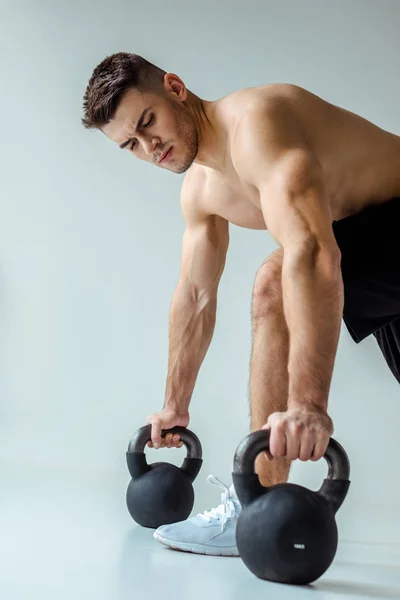 Sexy Svalnatý Kulturista Holým Trupem Cvičení Kettlebells Izolované Šedé — Stock fotografie