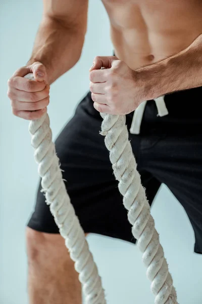 性感肌肉健美者赤身裸体运动与灰色战斗绳索的剪影 — 图库照片
