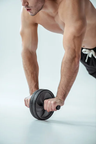 Cropped view of sexy muscular bodybuilder with bare torso exercising with ab wheel on grey background — Stock Image Cropped View Sexy Muscular Bodybuilder Bare Torso Exercising Wheel Grey Stock Picture