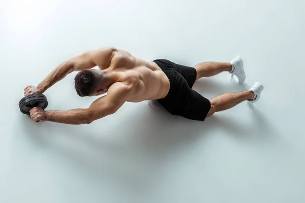 Overhead view of sexy muscular bodybuilder with bare torso exercising with ab wheel on grey background — Stock Image Overhead View Sexy Muscular Bodybuilder Bare Torso Exercising Wheel Grey Royalty Free Stock Images