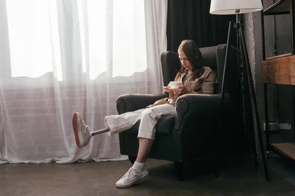 Young Woman Leg Prosthesis Drinking Coffee Armchair Home — Stock Photo, Image