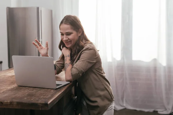 Güzel Gülümseyen Kız Mutfak Masasının Yanında Dizüstü Bilgisayarında Görüntülü Sohbet — Stok fotoğraf