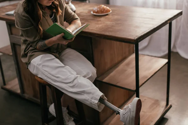 Vágott Kilátás Lány Láb Protézis Olvasókönyv Mellett Asztal Otthon — Stock Fotó