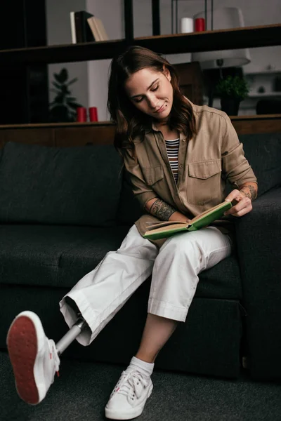Hermosa Mujer Joven Con Prótesis Pierna Libro Lectura Sofá Sala — Foto de Stock