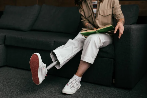 Vista Cortada Mulher Jovem Com Prótese Leitura Perna Livro Sofá — Fotografia de Stock