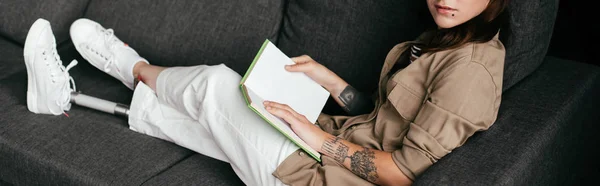 Cropped View Woman Prosthetic Leg Holding Book Sofa Panoramic Shot — Stock Photo, Image