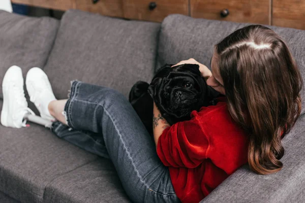 Fokus Selektif Gadis Dengan Kaki Prosthesis Membelai Pug Sofa — Stok Foto