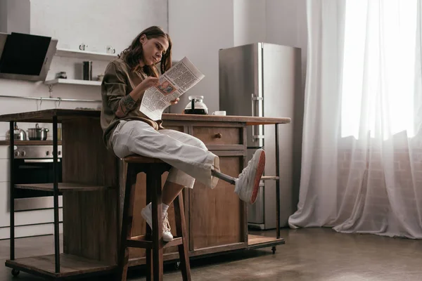 Vacker Flicka Med Protes Ben Läsa Tidningen Vid Köksbordet — Stockfoto