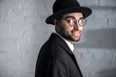 handsome and smiling jewish man in glasses looking at camera  clipart