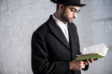 Gözlüklü yakışıklı ve genç Yahudi bir adam kitap okuyor. 