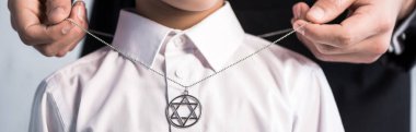 panoramic shot of jewish father wearing star of david necklace on son   clipart