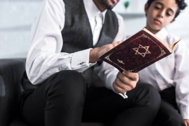 Yahudi bir baba ve oğulun evde tanak okuduğu görüntüler. 
