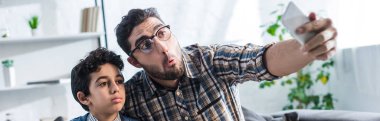 Yahudi babanın güzel oğluyla evde selfie çektiği panoramik bir fotoğraf. 