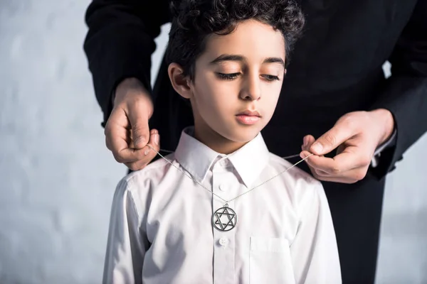 息子の上にデビッドネックレスの星を身に着けているユダヤ人の父のクロップドビュー — ストック写真