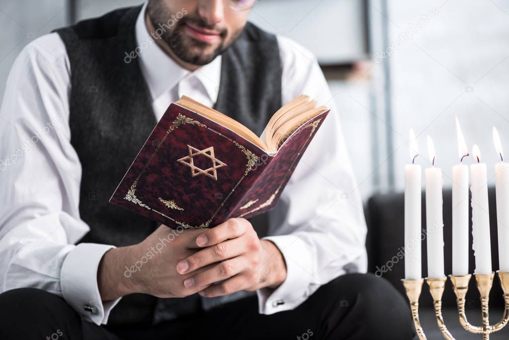 cropped view of jewish man reading tanakh in apartment 