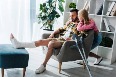 caring woman sitting near injured boyfriend 
