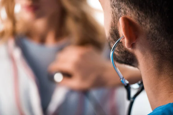 聴診器を持ち女性を診察する髭医者の — ストック写真