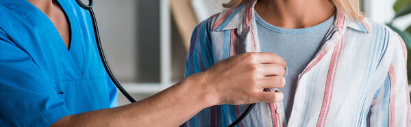 panoramic shot of doctor examining woman with stethoscope 