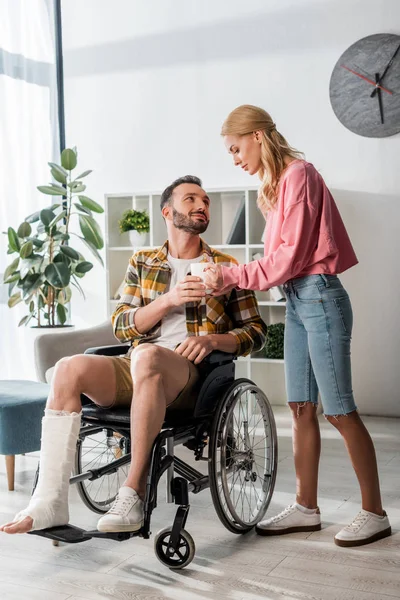 Atractiva Mujer Dando Taza Hombre Barbudo Silla Ruedas — Foto de Stock