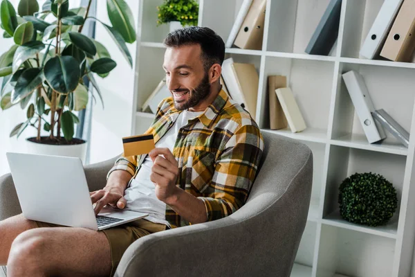 Happy Bearded Man Holding Credit Card While Online Shopping Home — Stock Photo, Image