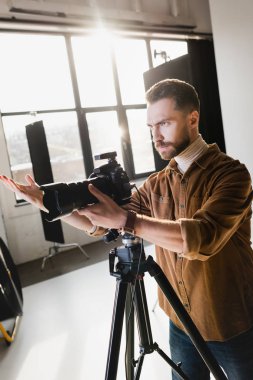 Sinirli fotoğrafçı sahne arkasında dijital kamerayla fotoğraf çekiyor.