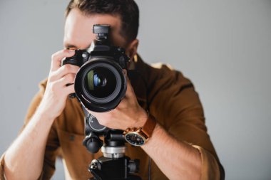 selective focus of photographer taking photo with digital camera on backstage clipart