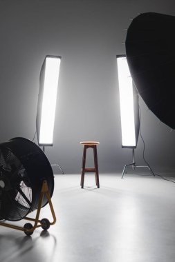 fan, yansıtıcı, ahşap tabure ve ışıklar sahne arkasında fotoğraf stüdyosunda.