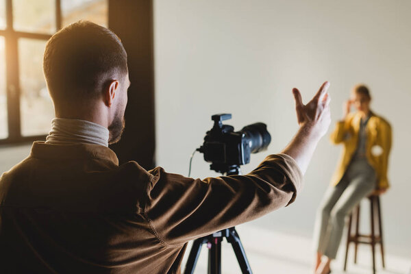 селективная направленность фотографа, указывающего рукой и смотрящего на модель
 