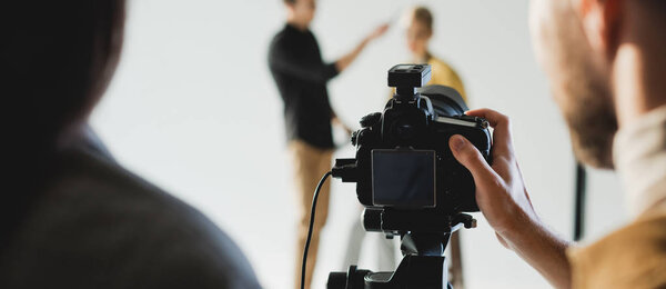 panoramic shot of producer and photographer taking photo of model and hairstylist on backstage 