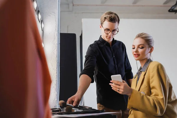 Makeup Artist Taking Cosmetic Brush Model Looking Smartphone Backstage — Stock Photo, Image