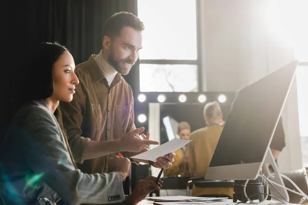 Selective Focus Producer Looking Computer Smiling Photographer Pointing Finger Backstage — Stock Photo, Image