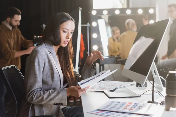 Attraktive Produzentin Sitzt Tisch Und Betrachtet Referenzen Hinter Der Bühne — Stockfoto