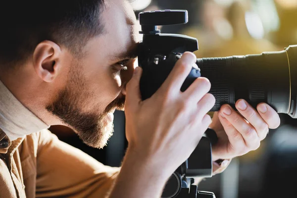 Widok Boku Uśmiechnięty Fotograf Robienie Zdjęć Aparatem Cyfrowym Kulisami — Zdjęcie stockowe