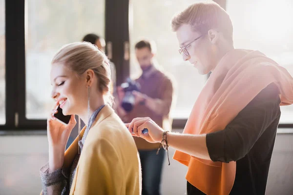 Side View Stylist Using Lint Roller Smiling Model Talking Smartphone — Stock Photo, Image