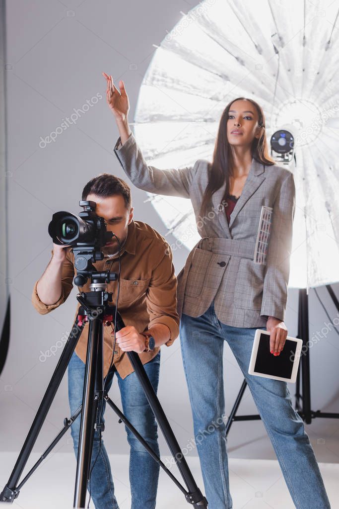 photographer taking photo and producer pointing with hand on backstage 