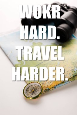 golden compass near map, binoculars and work hard travel harder letters on white  clipart