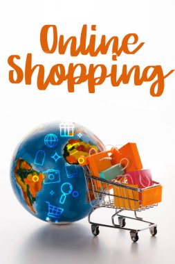 Dünya yakınında alışveriş torbaları olan oyuncak alışveriş arabasının seçici odağı ve beyaz, e-ticaret konsepti üzerine online alışveriş mektupları